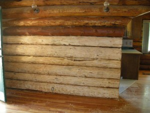 Log wall in a log home after it has been resanded but is still in need of restaining and chinking by Log and Timber Works Saskatchewan