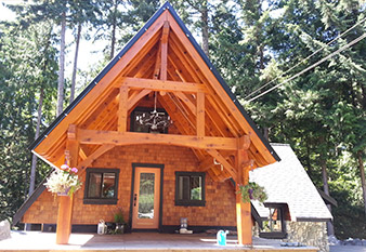 Custom designed timber frame entry on a timber frame hybrid home by Log and Timber Works Saskatchewan