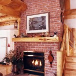 Log mantel above the fireplace in a log home by Log and Timber Works Saskatchewan