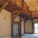 Timber posts, knee braces and balcony in a home by Log and Timber Works British Columbia