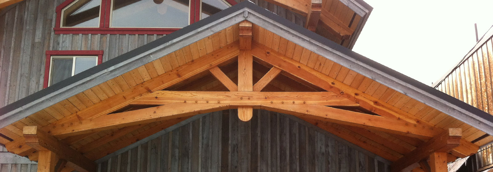 Custom designed timber frame entry with truss and exterior timber accents and elements by Log and Timber Works British Columbia