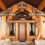 Custom designed timber frame entrance truss with cedar flare posts on a log home by Log and Timber Works Saskatchewan