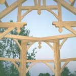 View through the timbers of a timber frame home under construction by Log and Timber Works