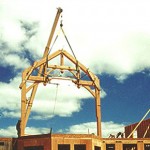 Timber frame home bent being raised with a crane by Log and Timber Works British Columbia