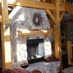 Fireplace in the living room of a custom designed timber frame home by Log and Timber Works Saskatchewan