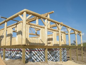Construction of a vertical log cabin with wrap around porch by Log and Timber Works Saskatchewan