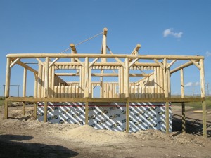 Vertical log cabin with wrap around porch being constructed by Log and Timber Works Saskatchewan