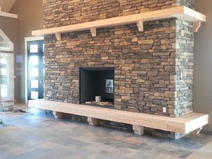 Timber mantel and hearth with adzed finish by Log and Timber Works British Columbia